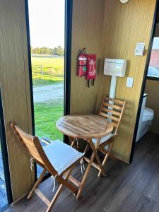 a table and two chairs next to a table and a window at Ritaville by Tiny Away in Eaton