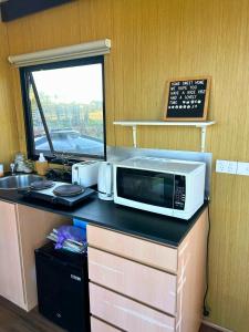 a microwave sitting on a counter in a kitchen at Ritaville by Tiny Away in Eaton