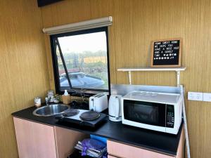 a kitchen with a counter with a microwave and a sink at Ritaville by Tiny Away in Eaton