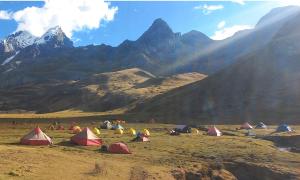 a group of tents in a field with mountains at Selena Camping in Tayapampa