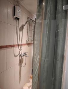 a shower in a bathroom with a shower curtain at Astoria Plaza Residential in Manila +5 photos