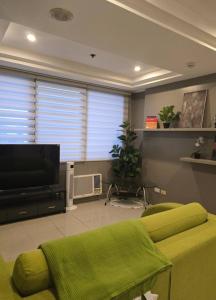 a living room with a couch and a flat screen tv at Astoria Plaza Residential in Manila