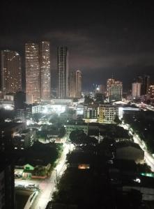 a city lit up at night with tall buildings at Astoria Plaza Residential in Manila