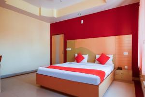 a bedroom with a large bed with red walls at Hotel Samar Palace Near Sodala Vivek Vihar Metro Station in Jaipur +25 photos