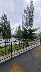 a metal fence with trees and a body of water at Hajeka Family 1 in Palayangan