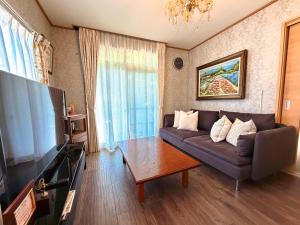 ein Wohnzimmer mit Sofa und Fernseher in der Unterkunft 叶 in Nishikichō