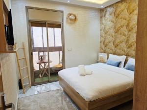 a bedroom with a bed and a large window at Azur Apartment essaouira in Essaouira