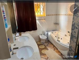 a bathroom with a toilet and a tub and a sink at Nuria luxurious one bed room apartment in Sekondi-Takoradi +12 photos