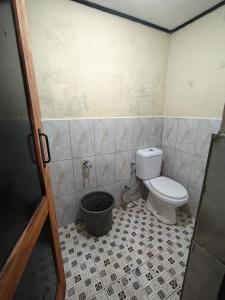 a bathroom with a toilet and a bucket in it at Bliss Family in Palayangan
