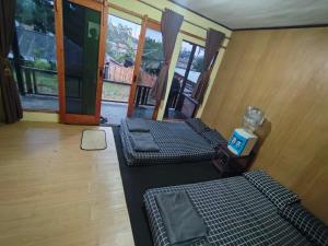 a room with three beds in a room with windows at Bliss Family in Palayangan