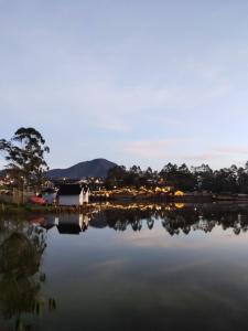 a view of a lake with a house in the background at Bliss Family in Palayangan