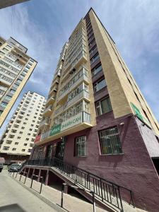 a tall building on a city street with buildings at Miga's guest house & tour in Ulaanbaatar
