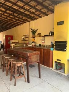 a kitchen with a wooden table and stools at Recanto da Caluninha in Esmeraldas