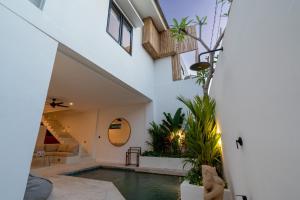 a house with a swimming pool and a staircase at Villa Ombak - 1BR Private Luxury Villa 150m from Seseh Beach in Canggu