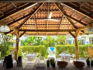 a wooden pergola with tables and chairs on a patio at Ela Kosher Hotel and Synagogue in Jacó