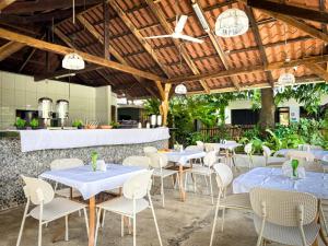 a restaurant with tables and chairs under a wooden ceiling at Ela Kosher Hotel and Synagogue in Jacó