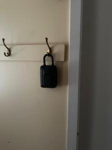 a black purse hanging on the wall of a room at 1500 Sqft Entire Basement Cozy Private Suite in Saskatoon +38 photos