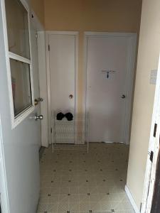 a hallway with a white door and a white tile floor at 1500 Sqft Entire Basement Cozy Private Suite in Saskatoon