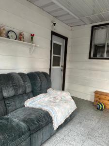 a living room with a couch with a blanket on it at 1500 Sqft Entire Basement Cozy Private Suite in Saskatoon