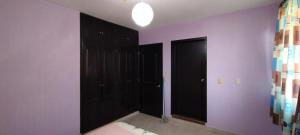 a bedroom with two black doors and purple walls at Hospedaje "Entre Amigos" in Comalcalco