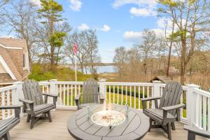 a patio with three chairs and a table with a fire pit at Buzzards Bay Family Beach Firepit CapeCodCanal in Bourne