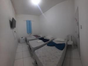a room with two beds and a tv in it at Pousada JM in Salgueiro