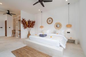 a white bedroom with a large bed and a ceiling fan at Villa Ombak - 1BR Private Luxury Villa 150m from Seseh Beach in Canggu +29 photos