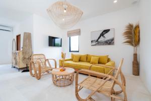 a living room with a yellow couch and chairs at Villa Ombak - 1BR Private Luxury Villa 150m from Seseh Beach in Canggu