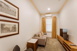 a living room with a couch and a television at Kincraig Hotel in Naracoorte