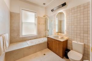 a bathroom with a tub and a sink and a toilet at Kincraig Hotel in Naracoorte