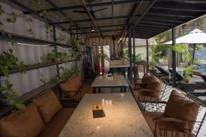 a restaurant with tables and chairs and plants at The Local Time Village in Siem Reap