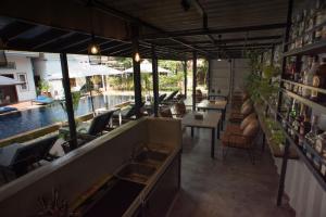 a restaurant with a pool and tables and chairs at The Local Time Village in Siem Reap
