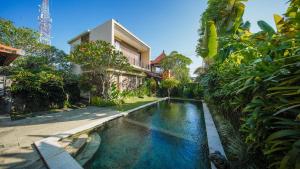 a swimming pool in front of a house at Pondok Massas Ubud in Ubud