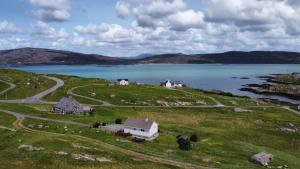 a house on a hill next to a body of water at Sealladh A’ Chaolais (Eriskay) in Eriskay