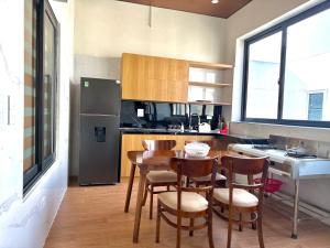 a kitchen with a table and chairs and a refrigerator at Amelia Sầm Sơn Boutique Holtel in Sầm Sơn