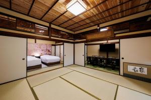 a room with a bed and a television in it at Hagizen in Hagi