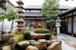 a garden in front of a building with a pagoda at Hagizen in Hagi