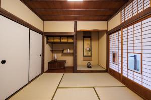 a japanese room with white walls and wooden ceilings at Hagizen in Hagi