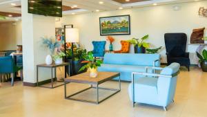 a waiting room with blue furniture and plants at Microtel Inn & Suites by Wyndham San Fernando in San Fernando