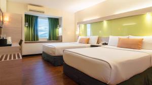 a hotel room with two beds and a window at Microtel Inn & Suites by Wyndham San Fernando in San Fernando +3 photos