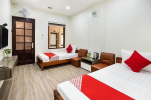 a hotel room with two beds and a chair at GTHT No152 in Hanoi