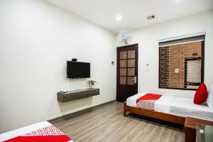 a bedroom with two beds and a flat screen tv at GTHT No152 in Hanoi