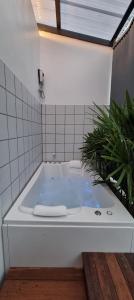 a jacuzzi tub in a bathroom with a plant at Amara Resort Hua Hin in Hua Hin