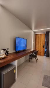 a living room with a television on a wooden table at Amara Resort Hua Hin in Hua Hin