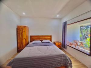 a bedroom with a bed and a large window at The sonteng hills in Sengkol +26 photos
