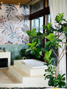 a bathroom with a bath tub with a plant at Lemeraude BnB in Hengchun South Gate