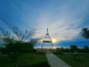 a large metal structure with the sun in the sky at Nara Paradise Beach in Narathiwat