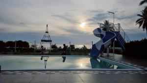 a person is standing next to a water slide at Nara Paradise Beach in Narathiwat