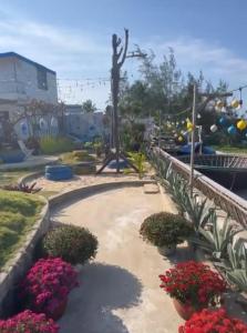 a statue of a person in a garden with flowers at Nhu's Cozy Home in Phước Thuận (1)