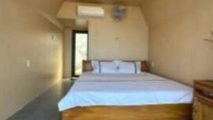 a bedroom with a large white bed in a room at Nhu's Cozy Home in Phước Thuận (1)